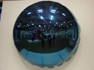 “Moon”, 1995-2000, reflecting “Balloon Dog” and the exhibition hall