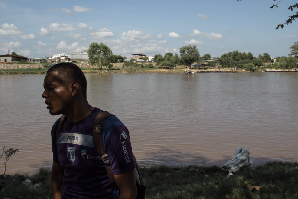 A central american immigrant is getting ready to cross the river and go to Mexico